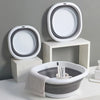 A set of white and gray collapsible silicone washbasins, including a large bowl and smaller basins, displayed on a white surf
