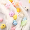 A collection of 18 soft, squishy animal stress relief toys in various pastel colors and shapes resting on a white fabric.