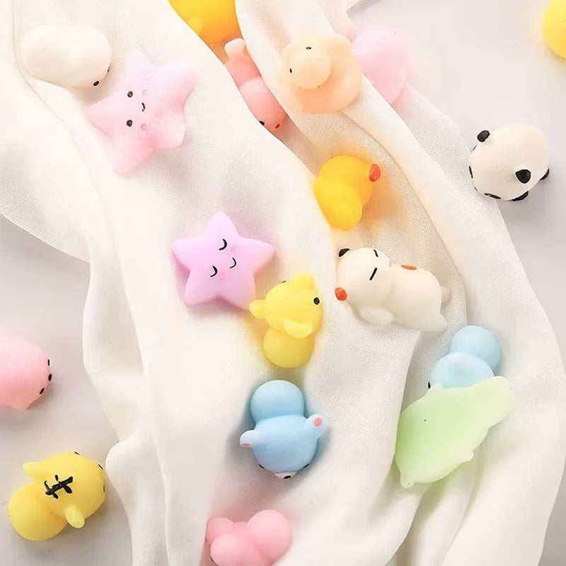 A collection of 18 soft, squishy animal stress relief toys in various pastel colors and shapes resting on a white fabric.