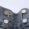 Silver metal button snaps attached to denim fabric for adjusting jeans waist