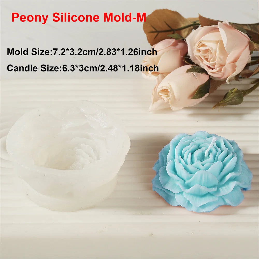 A silicone mold of a peony flower is shown next to a finished light blue flower, with rose leaves in the background.