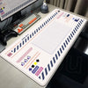 A large Japanese art mouse pad with a grid pattern and various icons is displayed on a desk next to a keyboard.