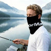 A man wearing a black neck gaiter is fishing on a body of water with mountains in the background.