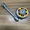 A metal fidget spinner with a long shaft and a circular weighted top, used for stress relief.