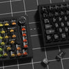 A close-up view of a black mechanical keyboard featuring an 115-key crystal clear RGB backlit keycap set.