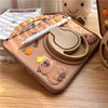 A silicone case featuring a cute cartoon capybara design for an iPad, shown on a wooden surface.