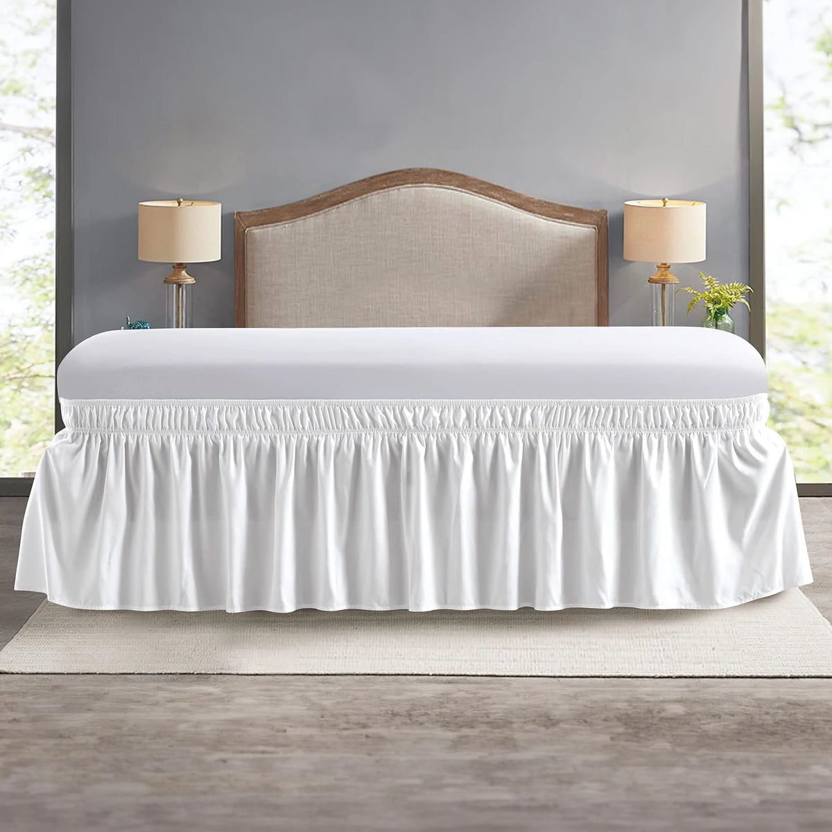 White adjustable wrap-around bed skirt with elegant ruffles displayed on a bed.