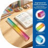 A colorful geometric cube drawing tool with a straight edge is shown next to a notebook and various colored pencils.