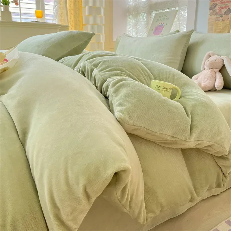 A close-up of a light green velvet bedding set featuring a duvet cover and pillows.