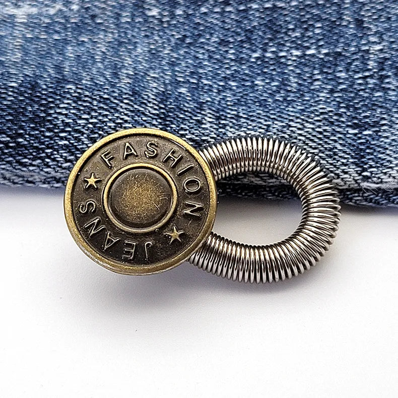 A round brass button with the word FASHION engraved on it and a silver spring-loaded extender.
