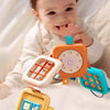 A baby is interacting with a colorful sensory folding activity cube and busy board designed for fine motor skills.