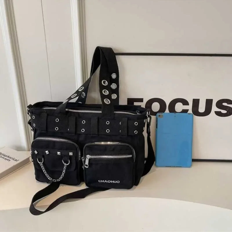 A black nylon shoulder bag with chain accents is displayed next to a blue object and a sign that reads FOCUS.