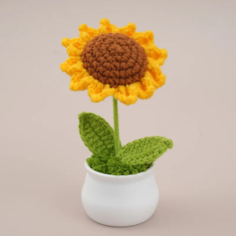 Handcrafted crochet sunflower with a brown center and yellow petals growing in a white pot