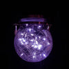 A glowing purple crackle glass solar lantern illuminating a dark background.