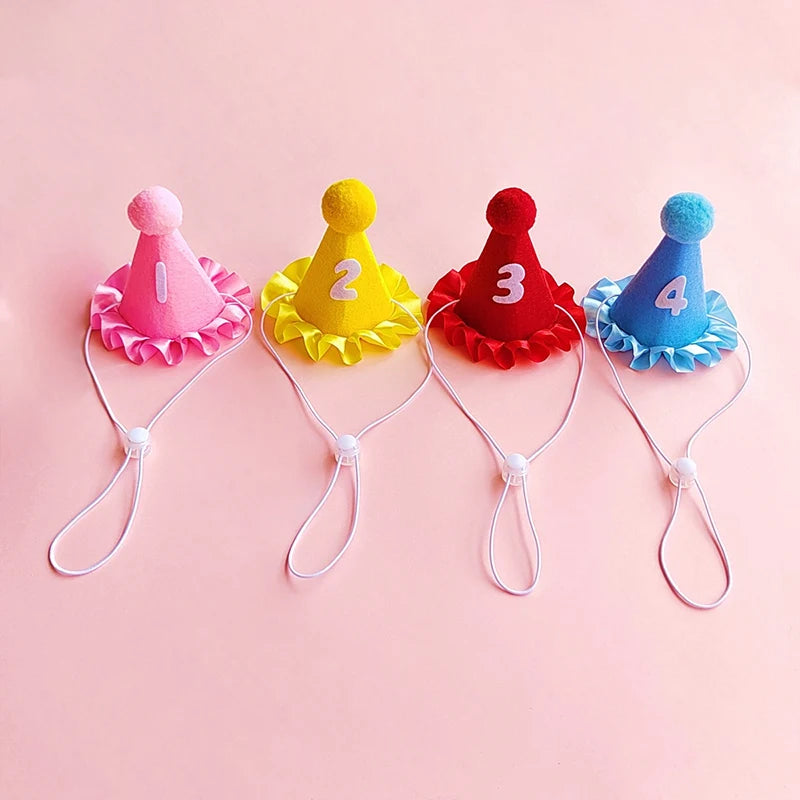 A set of four colorful pet birthday party hats with ribbons and bibs for cats and small dogs