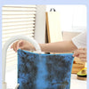A blue microfiber cleaning cloth is being washed under a faucet in a kitchen sink.