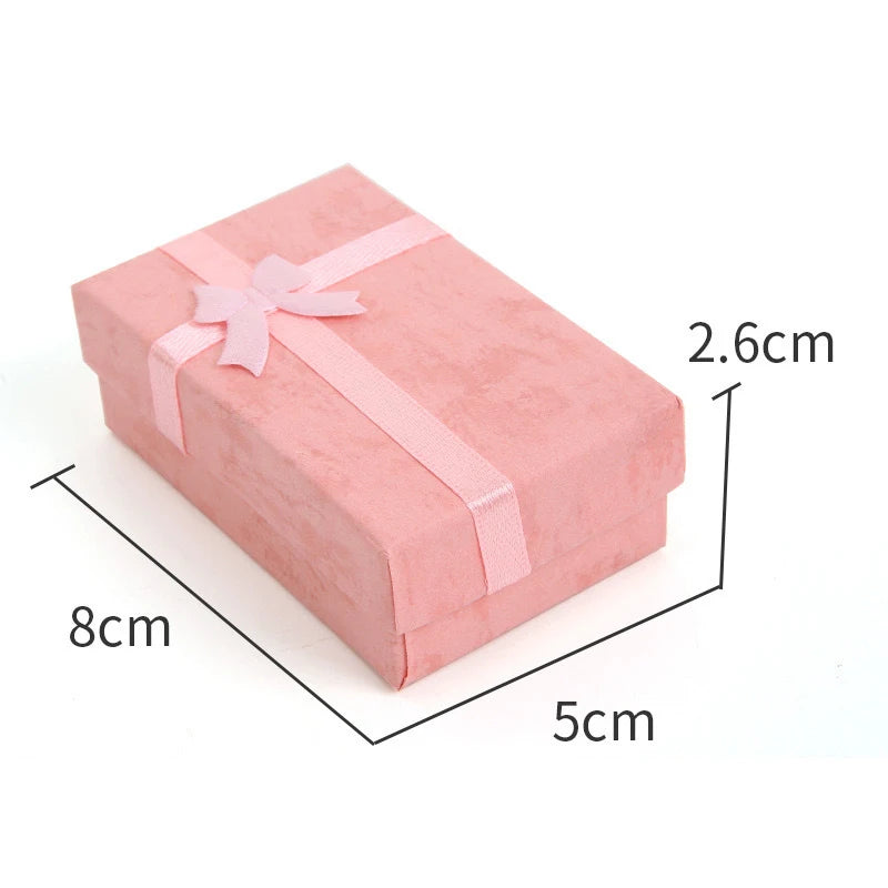 Pink velvet jewelry gift box with a pink ribbon and cushioned insert