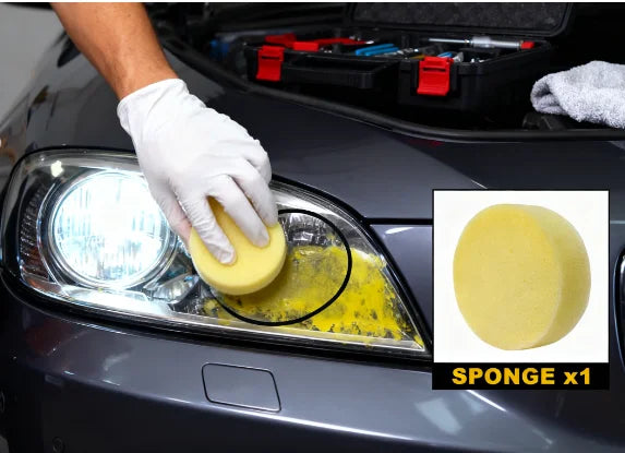 A gloved hand is cleaning a car headlight with a yellow sponge to restore clarity.