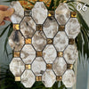 A square mosaic tile pattern featuring marbled gray and white stone in various shades of beige and gold accents.