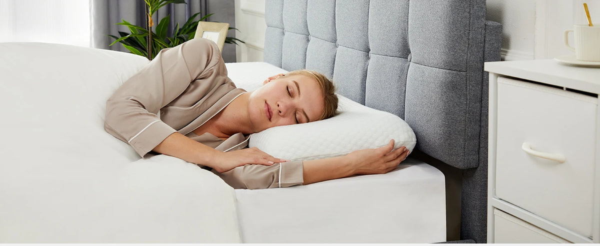 A woman is sleeping comfortably on a white memory foam pillow in a modern bedroom setting.