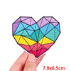 A colorful heart-shaped embroidery patch featuring a geometric design in shades of purple, blue, teal, yellow, and pink.