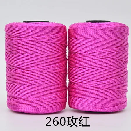 Two spools of bright pink 3-ply polyester knitting yarn for crochet and hand crafts