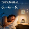 A woman is sleeping in bed next to a dimmable electric candle warmer lamp.