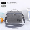 A gray insulated lunch bag with a strap is shown on a white marble surface.