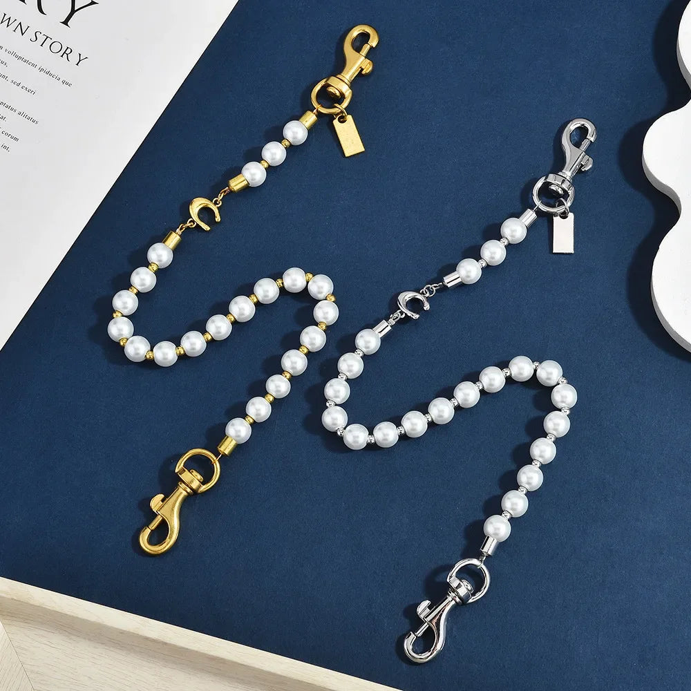 Gold and pearl beaded keychain featuring a letter C detail on a dark blue background.