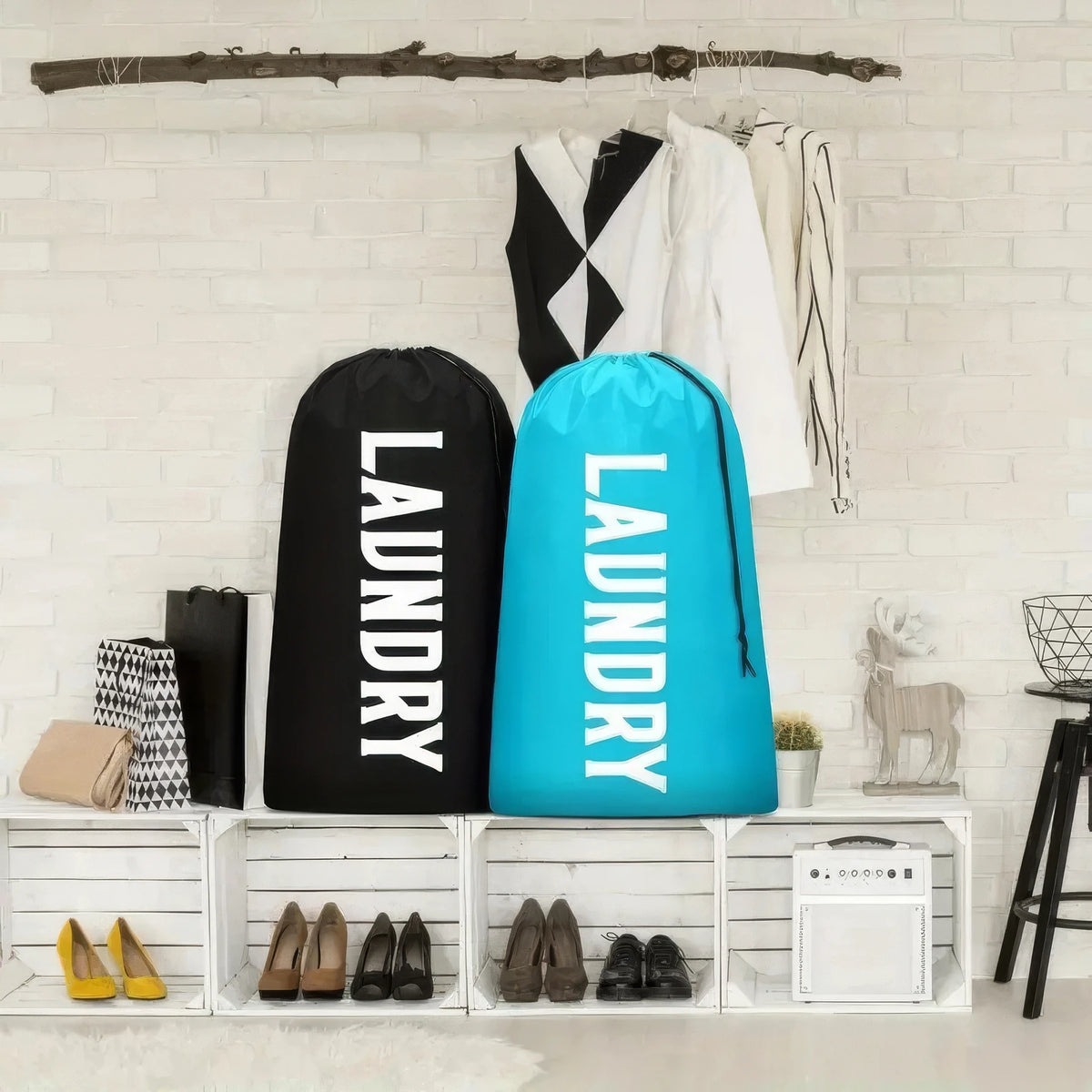 A collection of reusable laundry storage bags in black and bright blue displayed on a white brick wall.