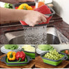 Deux paniers de drainage en silicone pliables remplis de légumes colorés étant lavés dans l'évier de cuisine.