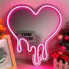 A neon sign shaped like a heart with a dripping effect, illuminated in pink and white light.
