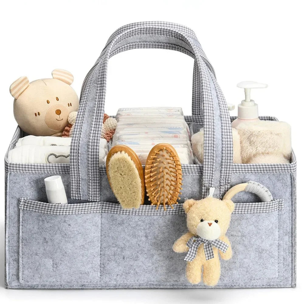 A gray floral diaper organizer bag filled with baby items including stuffed animals and grooming tools.