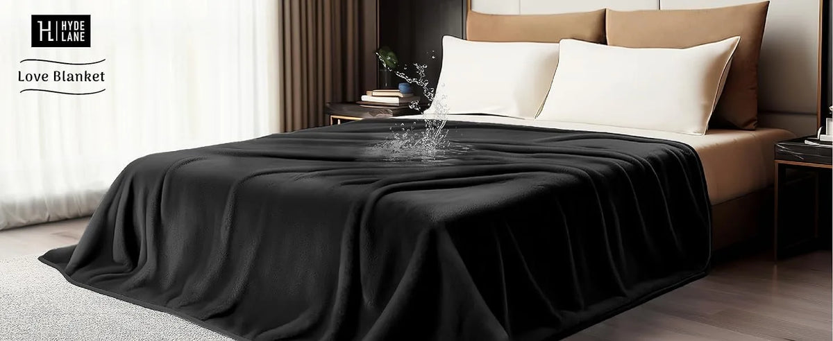 A black flannel blanket is draped over a bed, with white pillows visible in a bedroom setting.