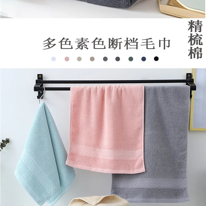 A set of six multi-colored cotton face towels hanging on a black rack.