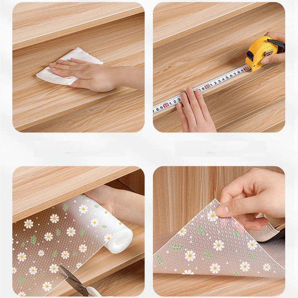 A hand uses a yellow ruler to measure the size of a Daisy Flower waterproof kitchen drawer mat placed inside a wooden drawer.