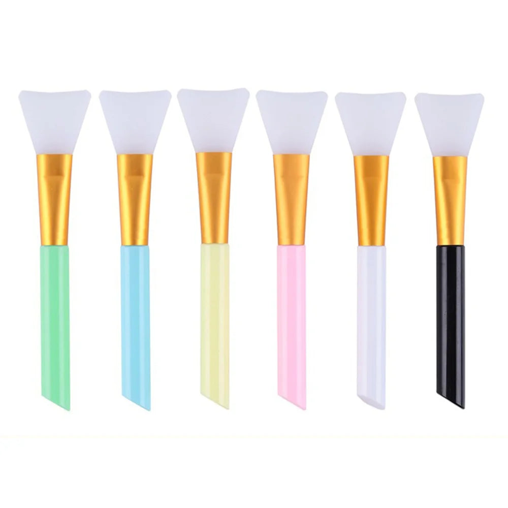 A set of six silicone facial mask brushes with gold and colored handles.