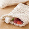 A natural sisal soap saver bag with an exfoliating mesh is shown, containing several pieces of soap.