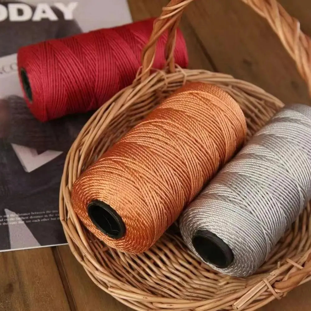 A basket filled with spools of red and gold colored ice cotton silk thread for knitting and crochet.