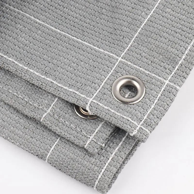 Gray HDPE privacy screen fabric with white stitching and a metal grommet detail.