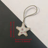 A handcrafted rhinestone bag charm featuring a starfish shape on a silver chain.