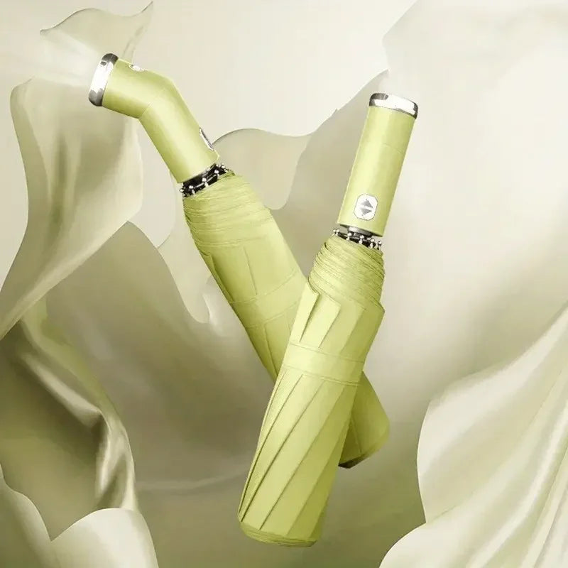 A close-up of a lime green automatic three-fold umbrella with silver accents, shown against a light background.