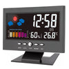 A digital weather station clock displaying the time, temperature, and humidity on a black screen.