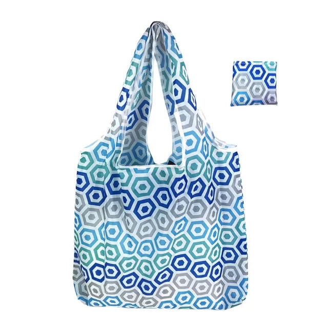 A reusable shopping tote bag featuring a blue and white geometric pattern, shown with an accompanying fabric swatch.