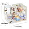 A wooden miniature dollhouse kit featuring a white frame, furniture, and decorative elements with LED lights.