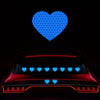 A car is decorated with reflective blue and red heart stickers on its body.