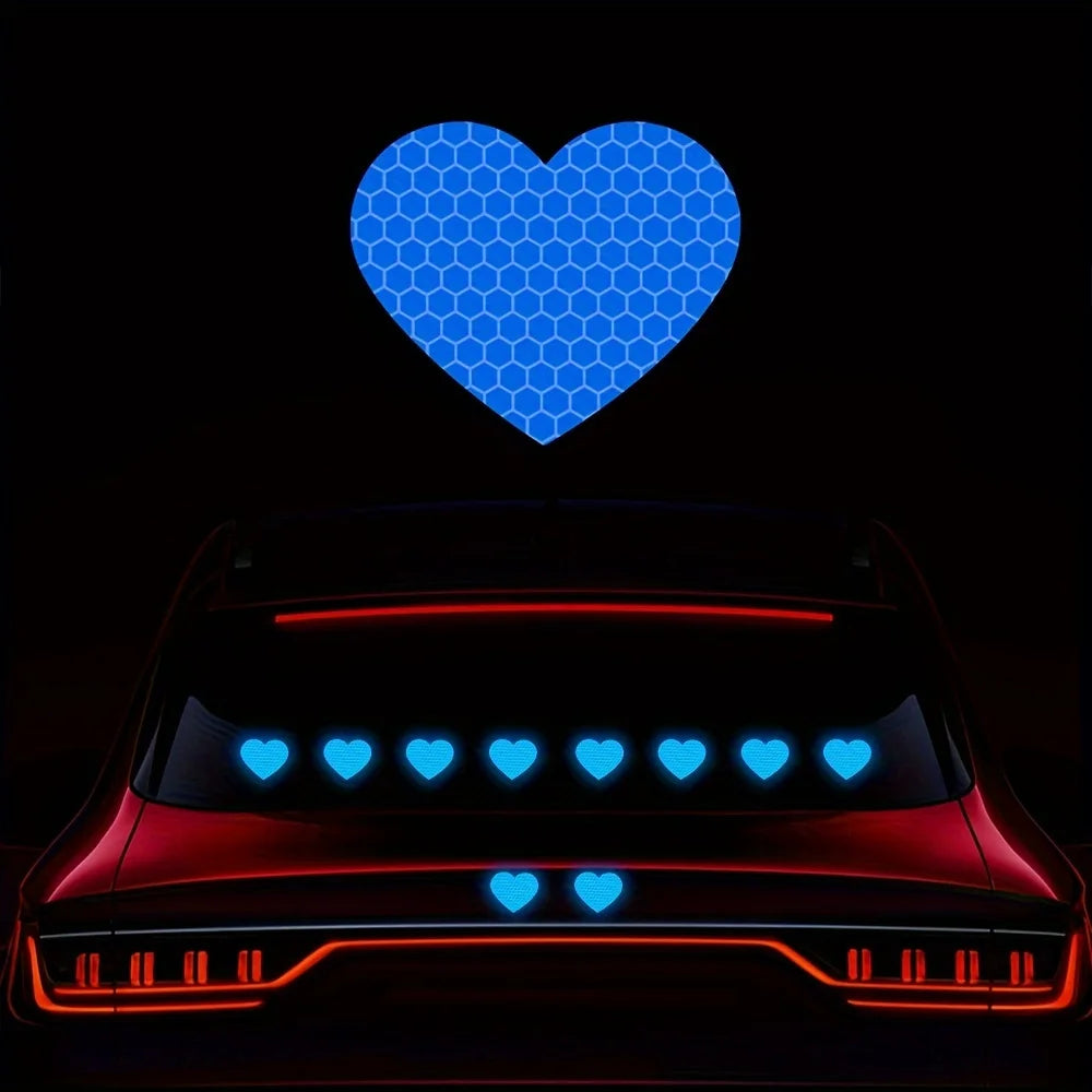 A car is decorated with reflective blue and red heart stickers on its body.