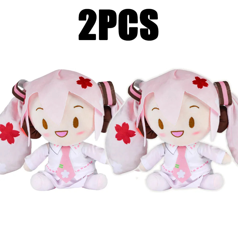 Two pink Hatsune Miku plush dolls with large ears and a white shirt and tie.