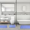 A modern bathroom featuring a toilet, sink area, and a white bathtub with blue bath mats on the floor.