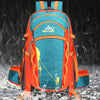An orange and teal hiking backpack is shown in a snowy outdoor environment.